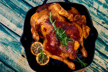 Baked Whole Chicken With Apples In Pan On Wooden Rustic Background. Served On Wooden Board. Christmas Chicken..