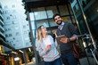 © NDABCREATIVITY - Beautiful young couple walking down the street with tablet