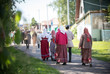 © KONSTANTIN SHISHKIN - People in traditional Russian clothes walk between wooden houses