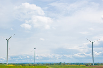 wind power plant in a field against the backdrop of a bright cloudy sky. wind generator close-up. green electricity, alternative energy