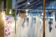 Few elegant wedding, bridesmaid ,evening, ball gown or prom dresses on a hanger in a bridal shop.