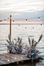 Sea Wedding Decor On The Coast. Evening Wedding Ceremony Near The Water