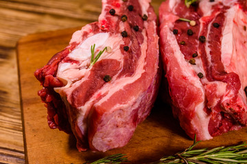 Raw pork ribs with spices and rosemary on a cutting board