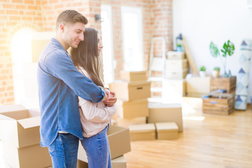 Poster - Beautiful young couple moving to a new house looking to side, relax profile pose with natural face with confident smile.