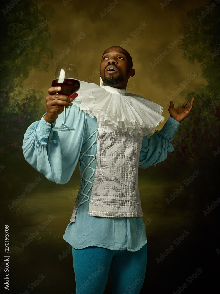 Grandee Young man as a medieval grandee or nobleman on dark studio background ...