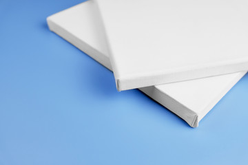 corners of canvas boards on blue background. white primed empty canvas on stretchers.