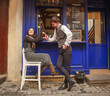 © okostia - Young guy in classic suit meets and flirting girl near city cafe in old town