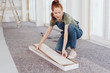 © contrastwerkstatt - Young woman removing paneling boards