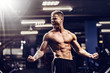 © ZaStock - Side view of a caucasian handsome fitness model posing in the gym. Man on diet flexing muscles and six pack abs