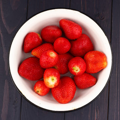 Poster - Strawberries in a plate on a dark wooden background