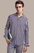 © micro - Young man in striped shirt posing with a book on gray background