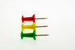 Red, green and yellow stationery buttons close-up on white background without shadow