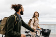 © Westend61 - Smiling couple with e bikes walking on promenade