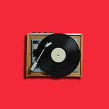 Vintage Turntable Vinyl Record Player On Red Background. Retro Sound Technology To Play Music