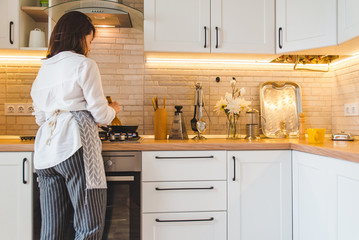 view from behind woman on kitchen cooking