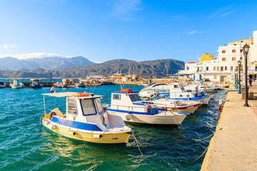 Wall Mural - Fishing boats in picturesque Pigadia port on Karpathos island at sunset time, Greece