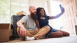 © Joshua Resnick - interracial couple taking selfie together while moving into new home