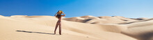 Panoramic Photo Of Lone Woman Standing In Sand Dunes With Blue Sky