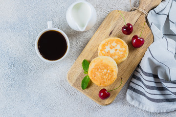 Wall Mural - Summer Breakfast with cottage cheese pancakes, cup of black coffee, milk on white table background. Top view