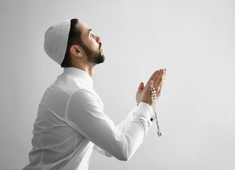 Wall Mural - Young Muslim man praying indoors