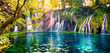 Last sunlight lights up the pure water waterfall on Plitvice National Park. Colorful spring panorama of green forest with blue lake. Great countryside view of Croatia, Europe. 