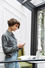 Poster - Attractive young woman standing at the cafe indoors