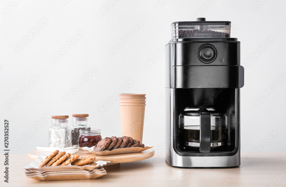 Modern coffee machine and sweets on kitchen table