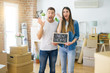 © Krakenimages.com - Young beautiful couple holding blackboard with new home text at new house very happy and excited, winner expression celebrating victory screaming with big smile and raised hands