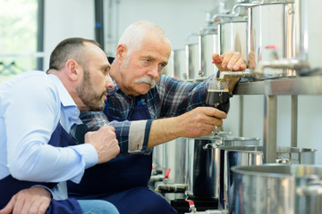 brewery worker taking sample out of container