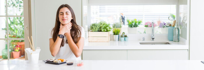 wide angle picture of beautiful young woman eating asian sushi from delivery shouting and suffocate 