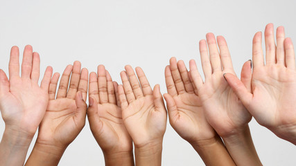 many raised hands in a row.. cooperation and Association of friends.