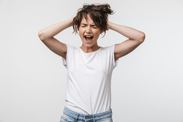 Canvas Print - Image of shocked woman with short hair in basic t-shirt screaming and grabbing her head