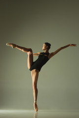 Graceful ballet dancer or classic ballerina dancing isolated on grey studio background. Showing flexibility and grace. The dance, artist, contemporary, movement, action and motion concept.