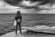 © Marco Taliani - Black and white view of a girl observing the sea with a lot of wind and cloudy sky