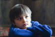 Emotional portrait Kid sitting alone and looking out with bored face, Low key light  of unhappy preschool child laying head down on table with thinking face, Cropped shot bored child face