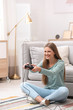 © New Africa - Emotional young woman playing video games at home
