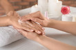© New Africa - Cosmetologist applying cream on woman's hand at table in spa salon, closeup