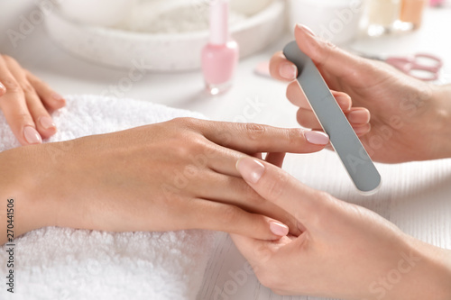 Fotomural Manicurist filing client's nails at table, closeup. Spa treatment