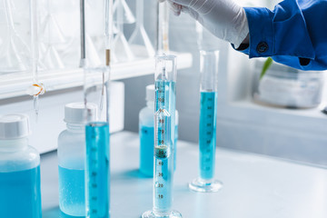 Analysis of the quality of liquids in a chemical laboratory, a device with equipment made of glass with a blue liquid