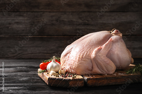 Fotografía Board with raw turkey and ingredients on wooden table