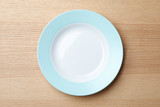 Fototapeta  - Stylish ceramic plate on wooden background, top view