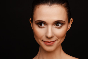 Wall Mural - Portrait of a beautiful woman with collected hair and bare shoulders on a black background