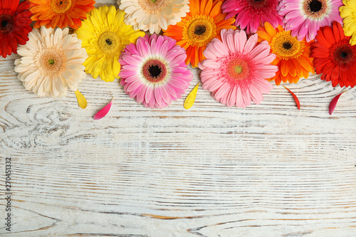 Photographie Beautiful bright gerbera flowers on wooden background, top view