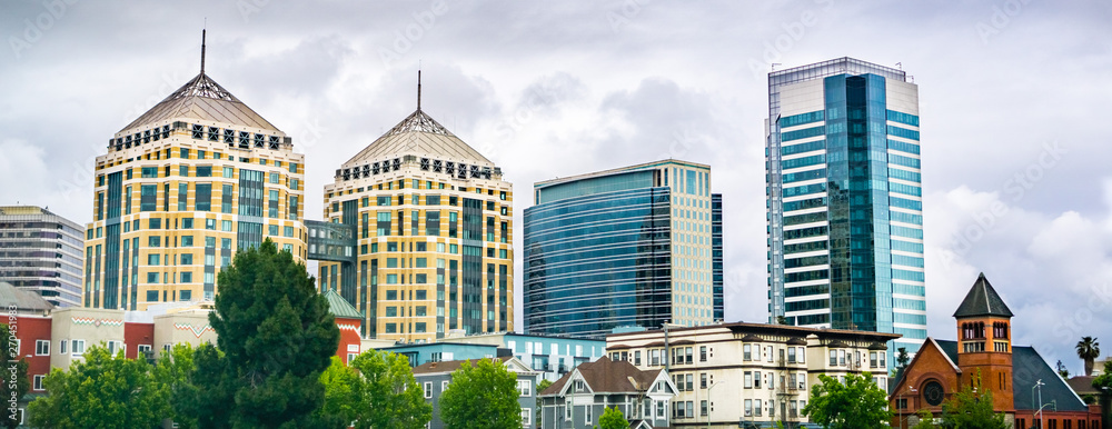 Modern buildings in downtown Oakland rising behind old ones; cloudy spring day; San Francisco bay area, California - obrazy, fototapety, plakaty 