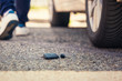 Car key fall on the asphalt road. Driver lost his vehicle keys and walks away.
