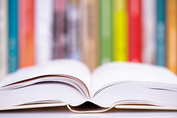 Close-up open book with library bookshelf toned background