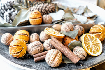 A set of dried fruits, nuts, and cones in a wide decorative vase in a restaurant. Autumn is a symbol of harvest, wealth. Vintage, macro