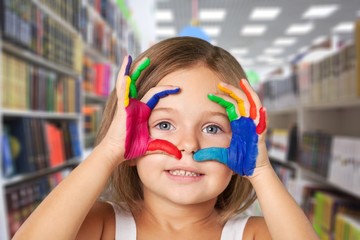 Wall Mural - Cute little girl with colorful painted hands on  background