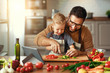 © JenkoAtaman - happy family father with son preparing vegetable salad .
