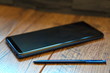 Blau-schwarzes Smartphone auf Holzuntergrund